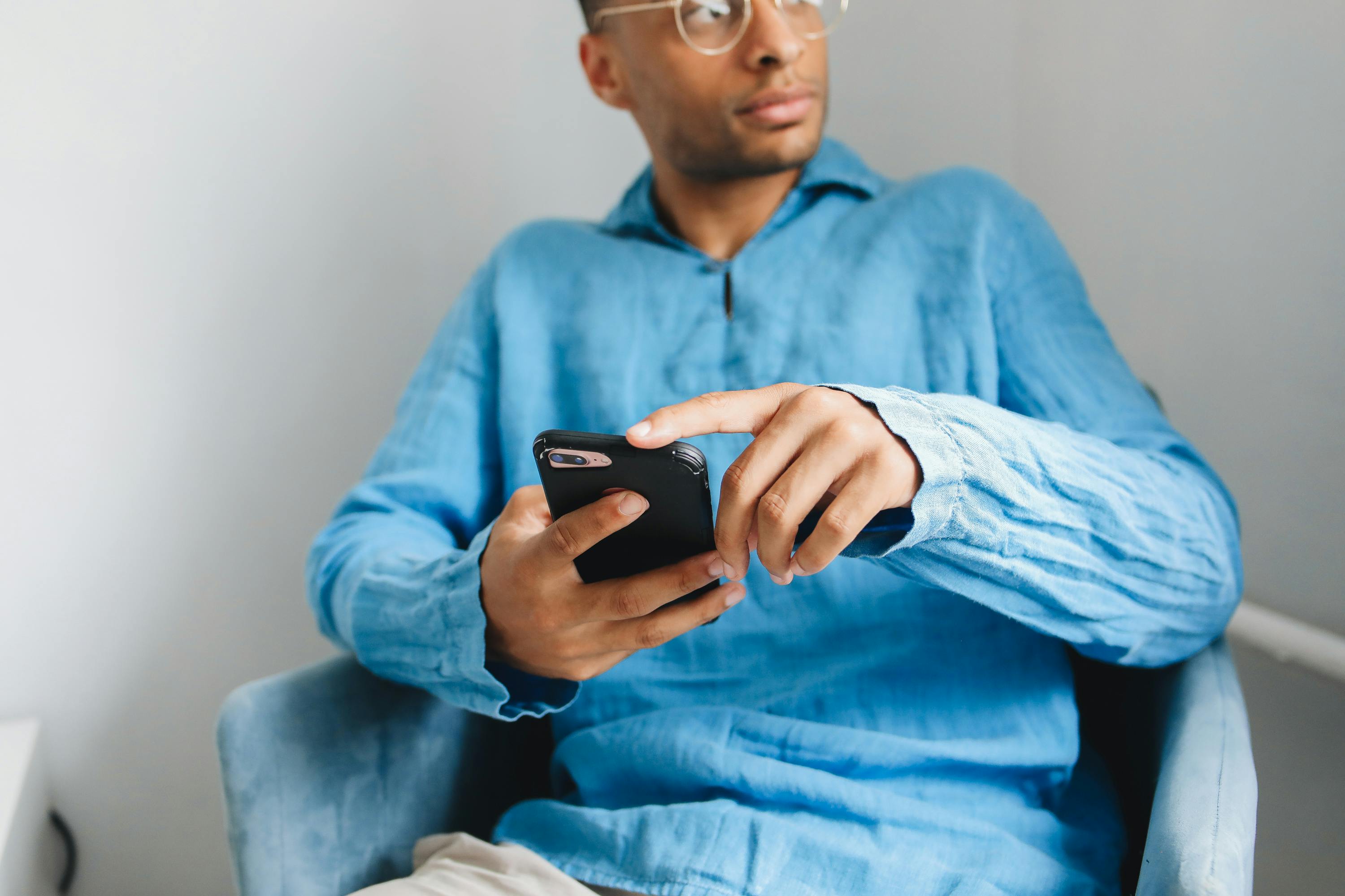 man on mobile phone wearing bright baby blue shirt