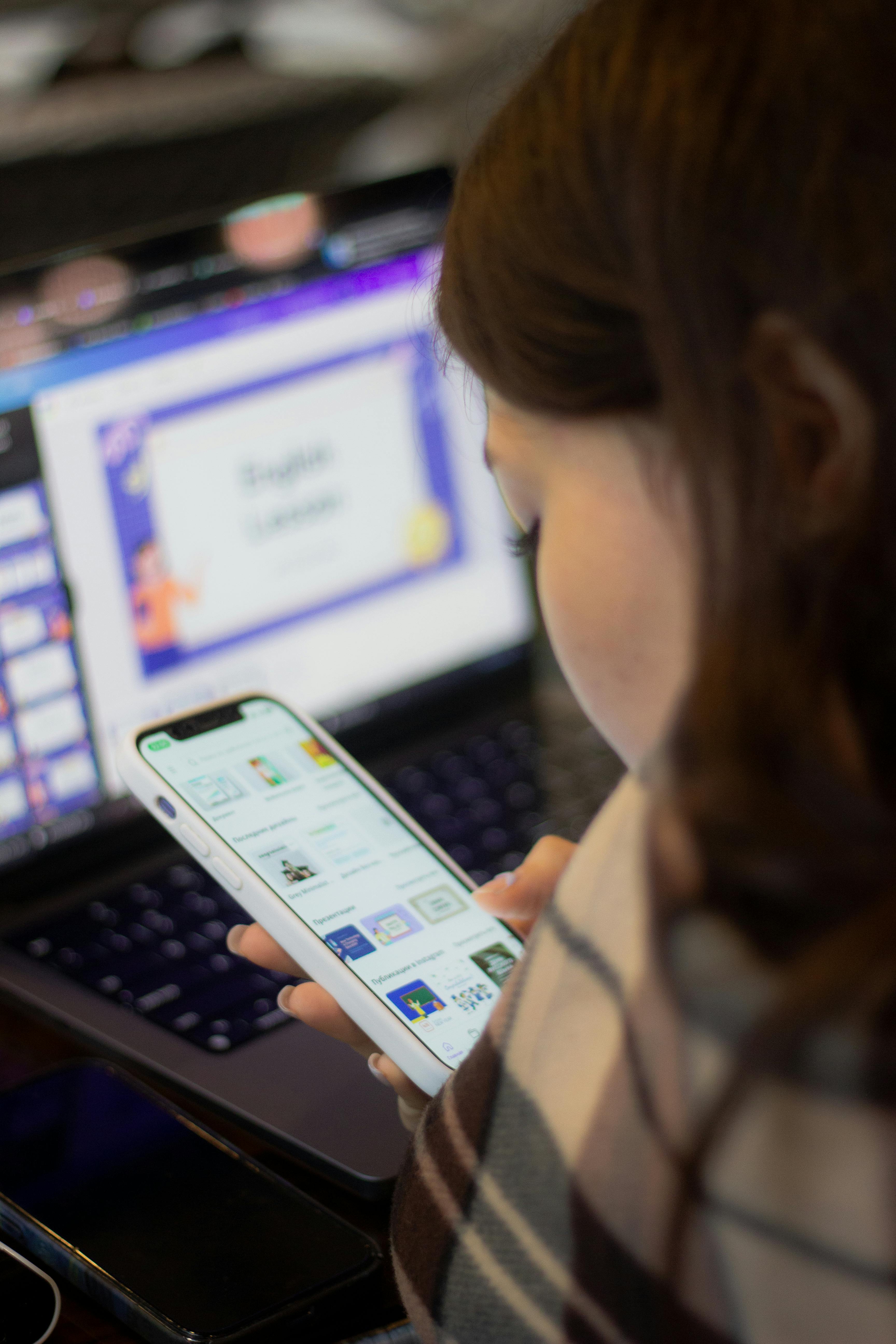 woman on a mobile phone with open laptop in back ground